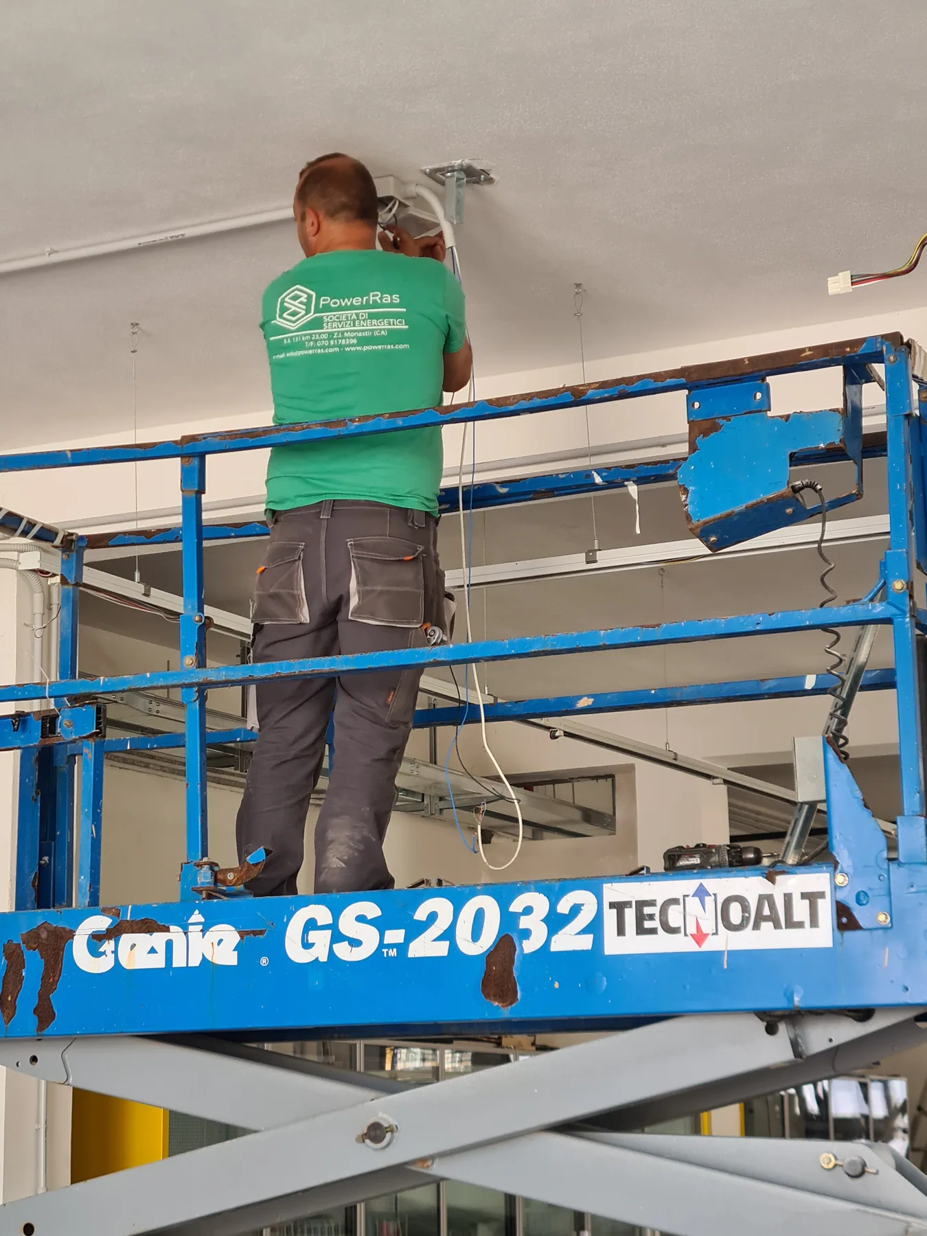 Operatore al lavoro su piattaforma elevatrice nel punto vendita